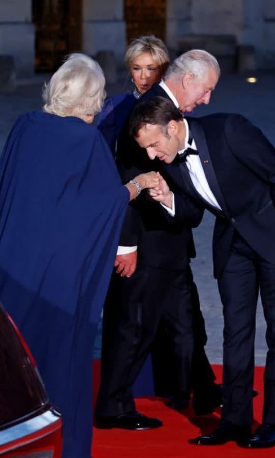 Macron plants a kiss on Queen Camilla's hand...